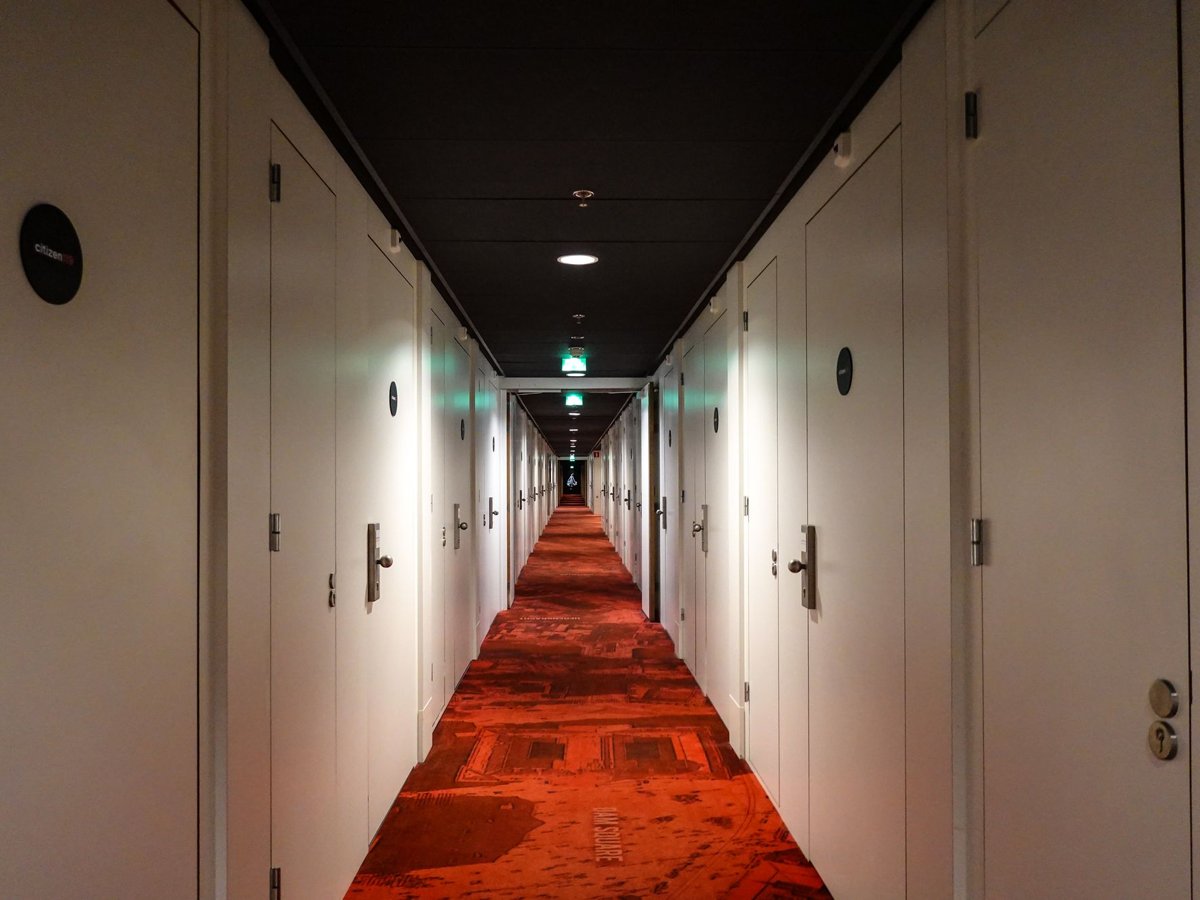 A long hotel corridor with guest room doors