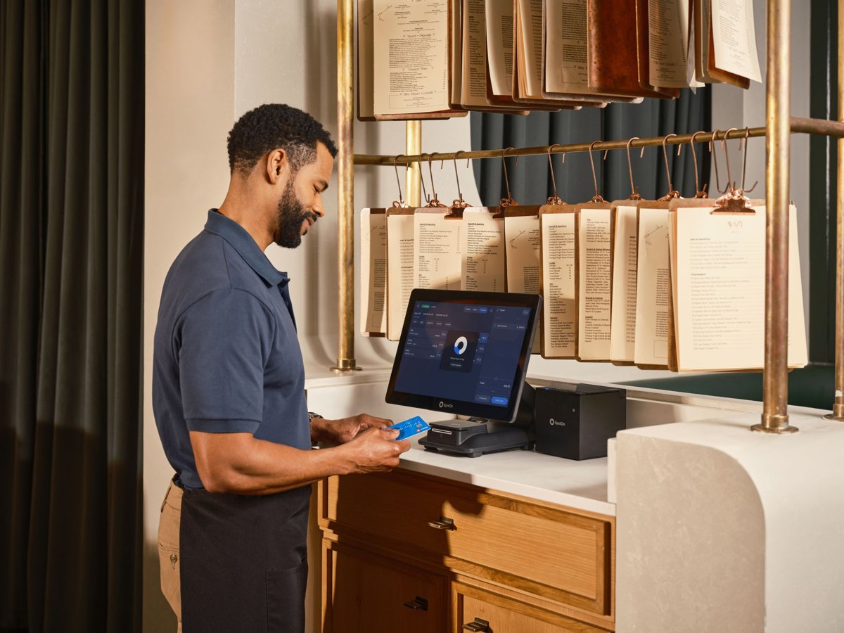 A restaurant server ringing up an order on a POS system