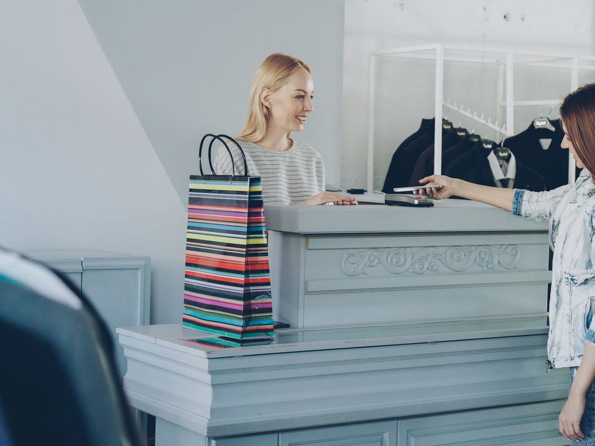A shopper paying at a boutique checkout counter